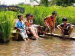 anak-anak-bersantai-di-bangku-tengah-sawah-mina-padi.jpg