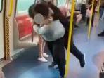 dua-pria-terlihat-saling-pukul-dan-lempar-di-sekitar-kereta-yang-sedang-melaju.jpg