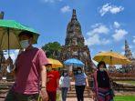 engunjung-dengan-masker-dan-membawa-payung-mengunjungi-kompleks-kuil-abad-ke-17-wat-chaiwatthanaram.jpg