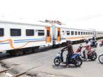 potret-pengendara-sepeda-motor-yang-berada-di-perlintasan-kereta-api.jpg