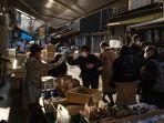 seorang-wanita-saat-orang-orang-berjalan-melalui-jalan-di-area-pasar-ikan-luar-tsukiji-di-tokyo.jpg