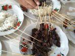 warga-mengonsumsi-sate-tubaka-di-keude-punteut-kecamatan-blang-mangat.jpg