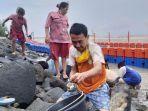 warga-sedang-mencari-kerang-bangkang-di-pantai-alam-indah-pai.jpg