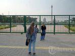 wisatawan-berfoto-di-area-luar-pagar-monumen-nasional-monas-jakarta-pusat.jpg