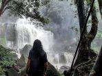 wisatawan-yang-berpose-dengan-latar-riam-kuweg.jpg