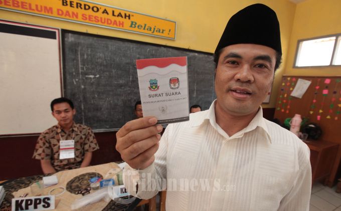 ACENG FIKRI NYOBLOS - Mantan Bupati Garut Aceng Fikri memperlihatkan surat suara sebelum melakukan pencoblosan dalam pelaksanaan Pemilihan Bupati dan Wakil Bupati (Pilbup) Garut 2013 di TPS 20, Kampung Copong, Desa Sukamantri, Kecamatan Garut Kota, Kabupaten Garut, Minggu (8/9).