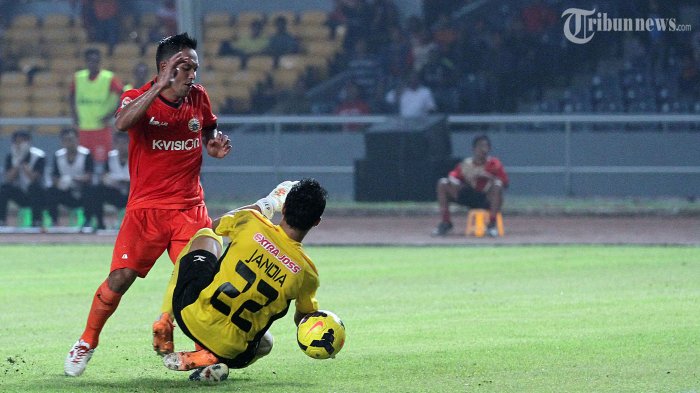 Penyerang Persija Jakarta, Rahmad Afandi (11) diganjal penjaga gawang Semen Padang, Jandia Eka Putra (22) dalam pertandingan lanjutan Indonesia Super League (ISL) di Stadion Utama Gelora Bung Karno (SUGBK), Senayan, Jakarta Pusat, Sabtu (8/2/2014) malam. Persija berhasil memenangi pertandingan dengan skor 2-0 lewat gol Rahmad Afandi dan Ivan Bosnjak.