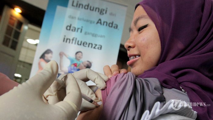 Seorang wartawan disuntik vaksin flubio di sela-sela acara media workshop di Kantor Bio Farma, Jalan Pasteur, Kota Bandung, Jumat (13/6/2014). Dalam acara yang mengambil tema Dedicated to Improve Quality of Life tersebut, PT Bio Farma sebagai salah satu perusahaan vaksin di dunia yang telah diakui oleh World Health Organization (WHO) itu berkomitmen untuk terus melakukan upaya dalam penelitian dan pengembangan vaksin baru, salah satunya vaksin untuk mencegah merebaknya korban yang terkena virus Middle East respiratory syndrome coronavirus (MERS-CoV) yang saat ini sedang mewabah di negara-negara Timur Tengah. TRIBUN JABAR/GANI KURNIAWAN