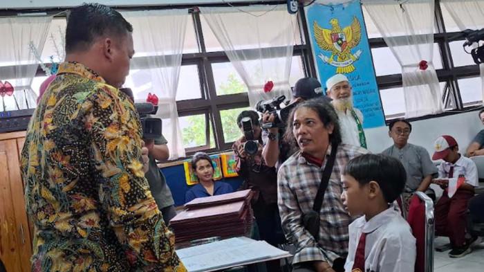 AYAH AMBIL RAPOR  - Pengemudi ojek online, Ali (47) dan Abinaya saat disapa Menteri Kependudukan dan Pembangunan Keluarga (Mendukbangga)/BKKBN Wihaji di SD Negeri Pondok Bambu 11, Jakarta Timur, Jumat (19/12/2025). Hari ini Kemendukbangga mengkampanyekan GEMAR atau Gerakan Mengambil Rapor Anak untuk mencegah anak mengalami kondisi fatherless.