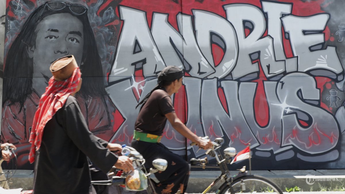 Warga melintas di depan mural bergambar Andrie Yunus di lokasi penyiraman air keras terhadap Aktivis Kontras, Andrie Yunus di Jalan Salemba I - Jalan Talang, Jakarta, Minggu (12/4/2026). Aksi tersebut sebagai peringatan 30 hari pasca penyerangan air keras terhadap Aktivis Kontras Andrie Yunus sebagai bentuk solidaritas sekaligus dorongan publik untuk penegakan hukum yang adil dan tuntas. TRIBUNNEWS/IRWAN RISMAWAN