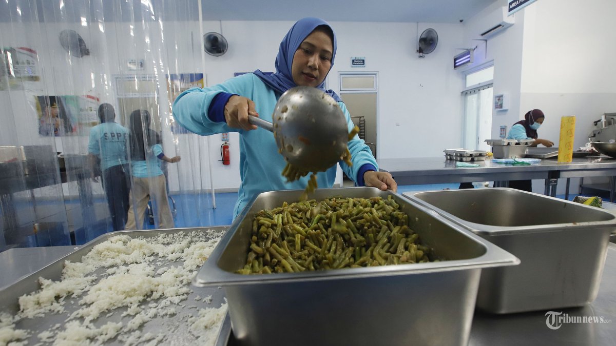 DAPUR SPPG PALMERAH - Petugas menyiapkan makanan untuk program Makan Bergizi Gratis (MBG) di SPPG Palmerah, Jakarta, Jumat (13/2/2026). Dapur SPPG yang dibangun di atas lahan seluas 900 meter persegi dengan luas bangunan 400 meter persegi tersebut memiliki berbagai fasilitas seperti filter air, hydro reverse osmosis untuk pemurnian air, food tray streamer electric sehingga mampu melayani hingga 2.987 penerima manfaat yang diharapkan menjadi contoh pengelolaan layanan gizi yang tujuan utamanya meningkatkan status gizi anak-anak dan meningkatkan kualitas hidup, serta mendukung pertumbuhan serta perkembangan anak. Tribunnews/Jeprima