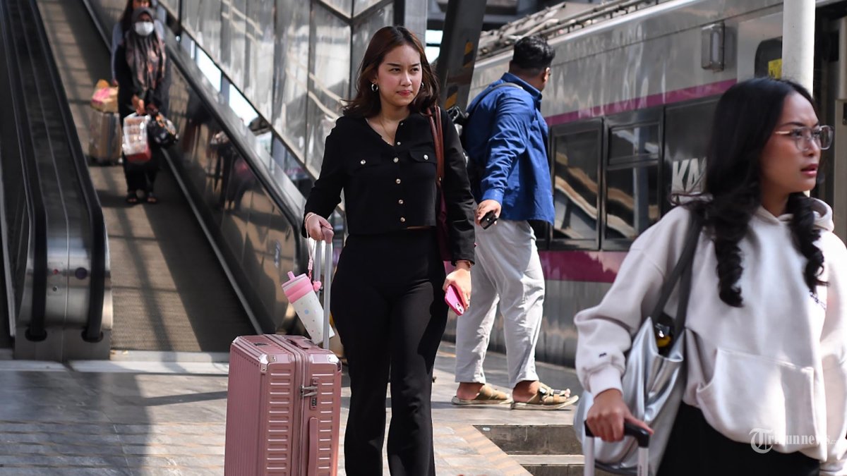 MUDIK - Calon penumpang berjalan menuju gerbong kereta api jarak jauh di Stasiun Kota Baru Malang, Jawa Timur, Sabtu (14/3/2026). PT Kereta Api Indonesia (KAI) Daerah Operasi 8 Surabaya mencatat hingga Sabtu (14/3/2026) pagi, sebanyak 8.731penumpang menggunakan kereta api di wilayah Malang Raya dengan rincian yakni keberangkatan 5.312 penumpang dan kedatangan 3.419 penumpang. PT KAI Daerah Operasi 8 Surabaya memprediksi puncak arus mudik yang diperkirakan terjadi pada tanggal 17 hingga 19 Maret 2026. SURYA/PURWANTO
