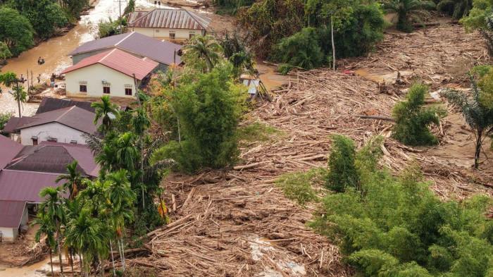 BANJIR BANDANG - Tumpukan kayu gelondongan ditemukan di Kecamatan Tuka, Tapanuli Tengah, Sumatera Utara, Kamis (4/12/2025). Kayu gelondongan tersebut terbawa banjir menghantam permukiman warga.