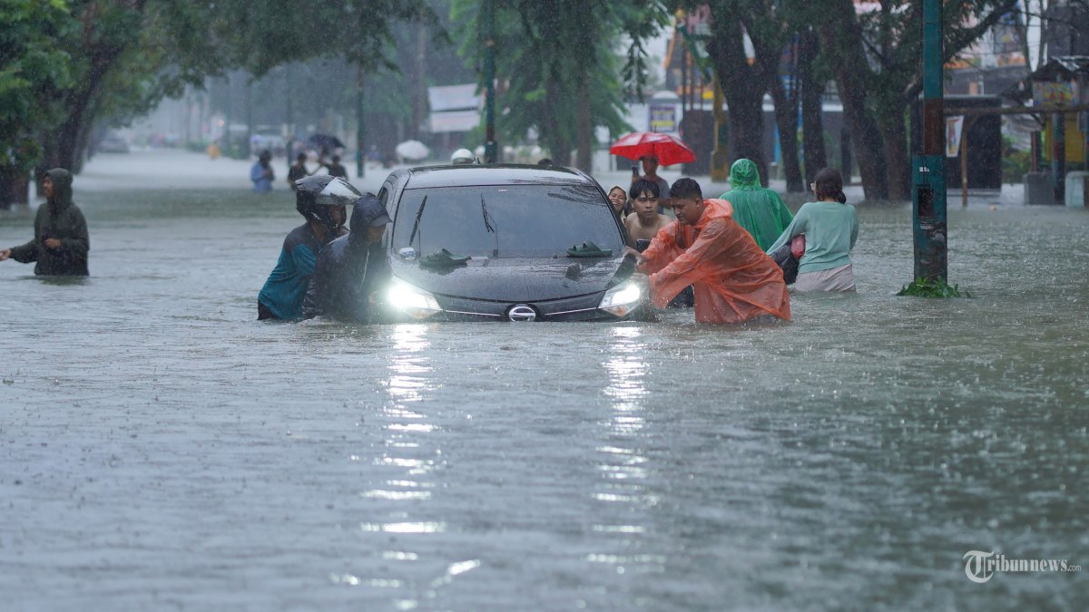 BANJIR DAN LONGSOR - Orang-orang mendorong kendaraan untuk menerobos banjir di Medan, Sumatera Utara, Indonesia, 27 November 2025. Sri Wahyuni ??Pancasilawati, kepala penanganan darurat, peralatan, dan logistik di Badan Penanggulangan Bencana Provinsi Sumatera Utara, mengatakan kepada Xinhua melalui telepon pada hari Kamis bahwa 29 orang tewas setelah banjir bandang dan tanah longsor melanda beberapa kabupaten dan kota di Provinsi Sumatera Utara, Indonesia. (Photo by Saddam/Xinhua)