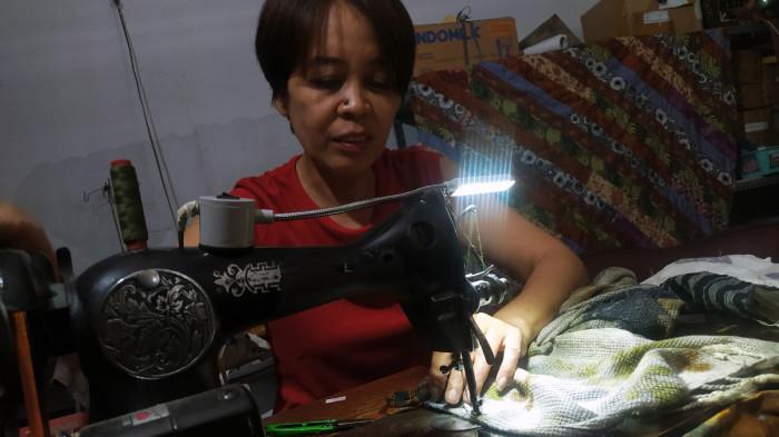 ALODIE ECOPRINT WONOGIRI - Dwi, karyawan Alodie Ecoprint saat menjahit lembaran kain ecoprint untuk disulap menjadi produk-produk bernilai jutaan rupiah.