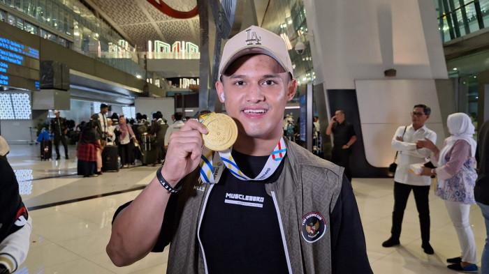 EMAS DAN REKOR DUNIA - Lifter andalan Indonesia, Rizki Juniansyah kembali menunjukkan eksistensinya dalam mengharum nama Indonesia di kancah internasional. Rizki juniansyah sukses meraih emas dan cetak rekor dunia di SEA Games 2025 Thailand. Bandara Soekarno-Hatta, Tangerang, Kamis (18/12/2025).