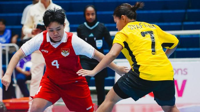 BERDUEL - Flank Timnas Futsal Putri Indonesia, Marsya Aulia (kiri) berupaya melewati hadangan pemain Malaysia, Syafiqah (kanan) pada laga lanjutan Grup A Piala AFF Futsal Putri 2026 di Nakhon Ratchasima, Rabu (25/2) malam WIB.