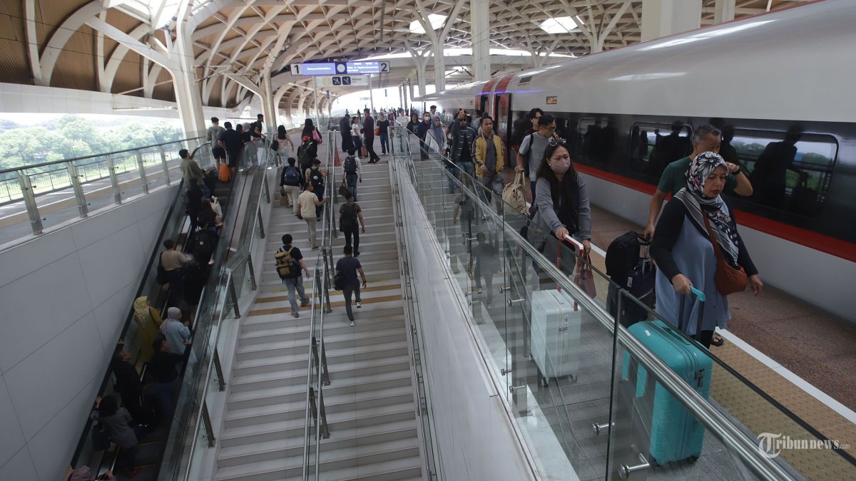 MUDIK 2026 - Penumpang bersiap naik kedalam kereta cepat whoosh di Stasiun Whoosh Halim pada H-2 Idulfitri 1447 H, Jakarta Timur, Kamis (19/3/2026). Berdasarkan pantauan Tribunnews.com pukul 12.05 WIB, area Stasiun Halim mulai dipadati calon penumpang. Di area lobby stasiun, tampak para penumpang mulai berdatangan dengan membawa gembolan hingga koper. Beranjak ke lantai 2 atau area memasuki peron, suasana penumpang makin ramai. KCIC mencatat penjualan tiket Whoosh pada periode Angkutan Lebaran 2026 mulai menunjukkan tren peningkatan menjelang Hari Raya Idulfitri. Total tiket yang telah terjual sampai dengan saat ini sudah mencapai sekitar 133 ribu tiket untuk periode 13 hingga 30 Maret 2026. Tribunnews/Jeprima