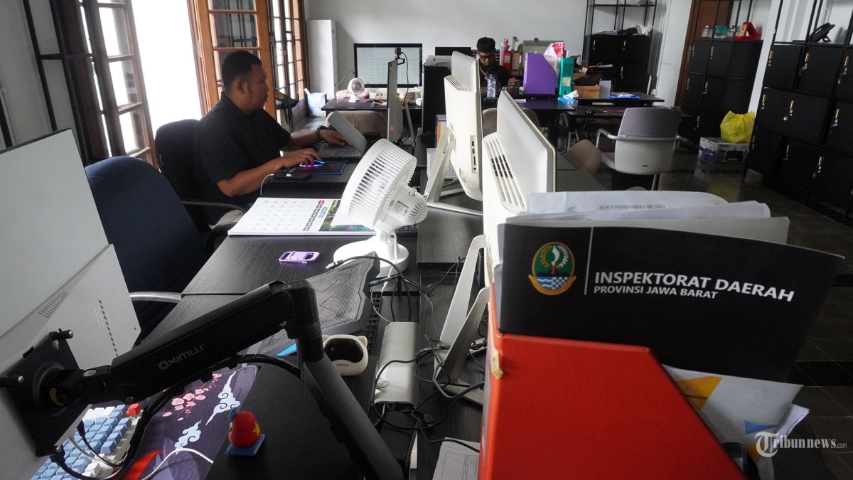 PENERAPAN WFH - Dua orang aparatur sipil negara (ASN) menyelesaikan pekerjaan sementara sejumlah kursi lainnya tampak kosong dan lampu dipadamkan saat hari pertama penerapan work from home (WFH), di salah satu ruangan di Gedung Sate, Kota Bandung, Jawa Barat, Kamis (6/11/2025). Suasana di kantor Gubernur Jawa Barat ini nampak sepi, sunyi dan sedikit gelap karena sebagian besar ASN menerapkan bekerja dari rumah. Uji coba penerapan WFH ini dilakukan diseluruh Organisasi Perangkat Daerah (OPD) non pelayanan sebagai bagian dari upaya efisiensi anggaran. (TRIBUN JABAR/GANI KURNIAWAN)