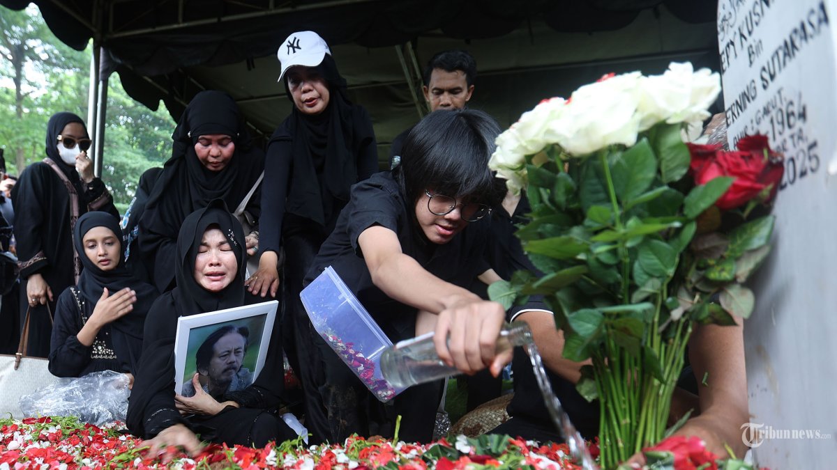 SUASANA HARU - Istri Epy Kusnandar, Karina Ranau didampingi sang anak Quentin Stanislavski serta keluarga melakukan tabur bunga diatas makam Epy Kusnandar di TPU Jeruk Purut, Jakarta Selatan, Kamis (4/12/2025). Karina Ranau tampak terus memeluk foto mendiang suaminya saat prosesi pemakaman. Prosesi pemakaman dihadiri oleh rekan-rekan Epy Kusnandar dari serial Preman Pensiun. Tribunnews/Jeprima