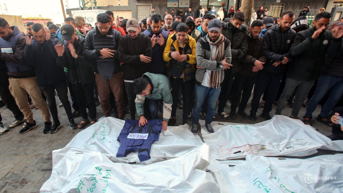 Para pelayat menghadiri pemakaman anggota pers yang tewas dalam serangan Israel, di Rumah Sakit al-Awda di kamp pengungsi Nuseirat di Jalur Gaza tengah, pada 26 Desember 2024. - Saluran TV Palestina yang berafiliasi dengan kelompok militan Jihad Islam mengatakan lima jurnalisnya tewas pada tanggal 26 Desember, dalam serangan Israel terhadap kendaraan mereka, dan militer Israel mengatakan mereka menargetkan ?sel teroris?. Sebuah rudal menghantam truk penyiaran para jurnalis yang sedang diparkir di kamp Nuseirat di Gaza tengah, menurut pernyataan dari majikan mereka, Al-Quds Today. (Photo by Eyad BABA / AFP)