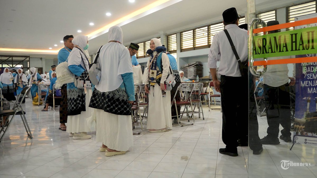 MASUK ASRAMA HAJI - Jamaah calon haji menikmati sajian makan siang di Asrama Haji Sukolilo Surabaya, Selasa (21/4/2026).Dua kloter pertama asal Kabupaten Probolinggo ini selain menerima paspor, gelang, dan living cost juga akan diterimakan kartu nusuk atau identitas khusus jemaah haji. SURYA/HABIBUR ROHMAN)