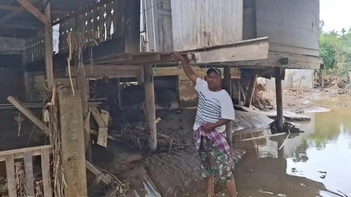 KORBAN BANJIR - Jufri (55) warga Blang Cut, Pidie Jaya, berdiri pilu menyaksikan pemulihan pascabanjir setelah kehilangan ibunya terseret arus.