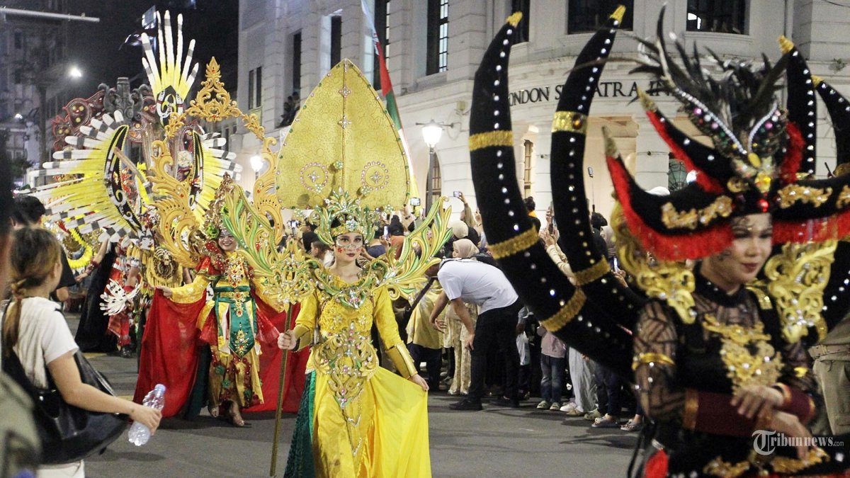 KARNAVAL HUT MEDAN - Peserta Colorful Medan Carnival mengenakan kostum kreasi saat melintas di kawasan Lapangan Merdeka, Medan, Jumat (5/7/2025) malam.