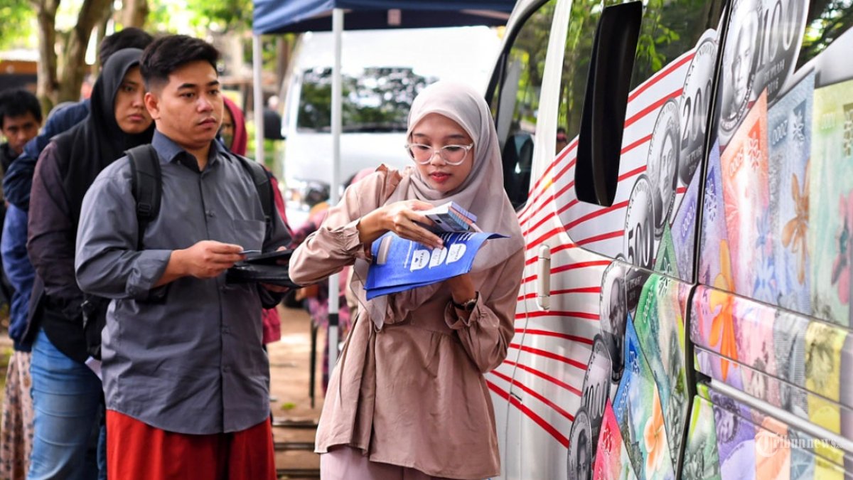UANG BARU - Warga menukarkan uang di mobil kas keliling Bank Indonesia Malang di Taman Merjosari, Kota Malang, Jawa Timur, Kamis (19/2/2026). Bank Indonesia Malang mulai membuka layanan penukaran uang rupiah baru dalam rangka memenuhi kebutuhan masyarakat jelang lebaran 2026. Layanan penukaran uang rupiah di wilayah kerja Bank Indonesia Malang ini dibuka mulai 19-26 Februari 2026 untuk kas keliling dan 26-27 Februari 2026 untuk loket perbankan. SURYA/PURWANTO