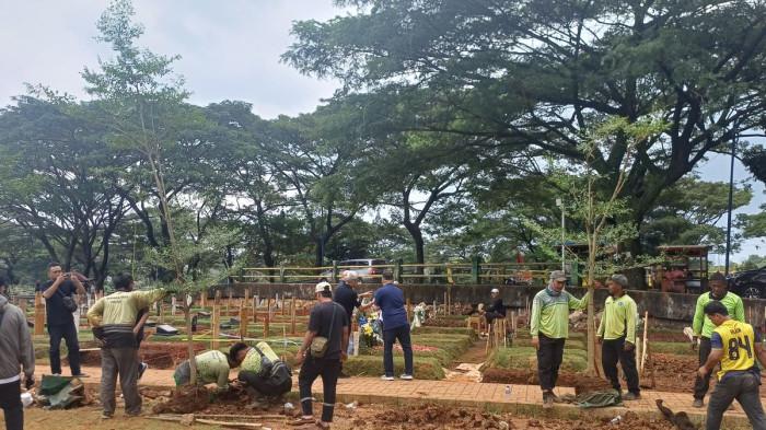 TANAM POHON - Petugas menanam pohon di sekitar makam Vidi Aldiano di TPU Tanah Kusir, Jakarta Selatan, Rabu 25/3/2026).