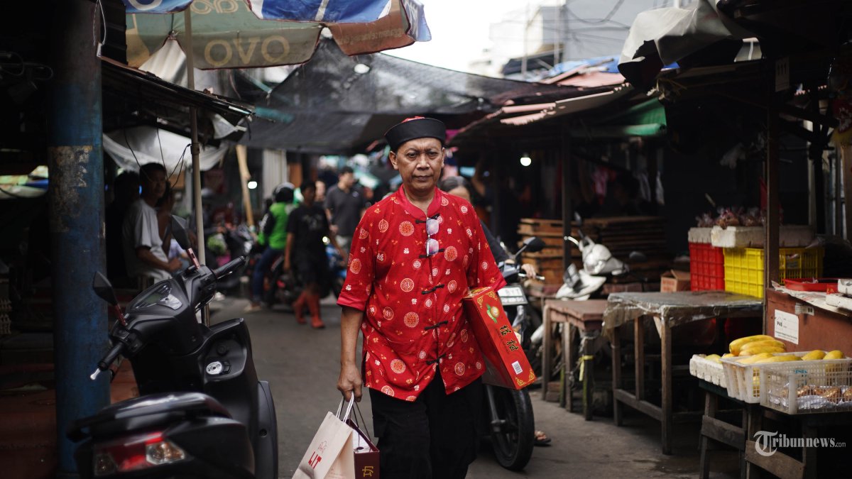 KAWASAN PECINAN - Seorang pria memakai baju tradisional Tionghoa berjalan di Pasar Petak Sembilan Glodok Jakarta Barat, Senin (16/2/2026). TRIBUNNEWS/HERUDIN