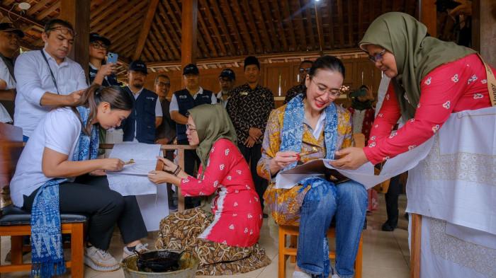 KUNJUNGAN MENTERI PARIWISATA - Menteri Pariwisata Widiyanti Putri Wardhana bersama Wamenpar Ni Luh Puspa mencoba praktik membuat batik saat kunjungannya ke Desa Wisata Wukirsari, DIY, Kamis (23/1/2025).