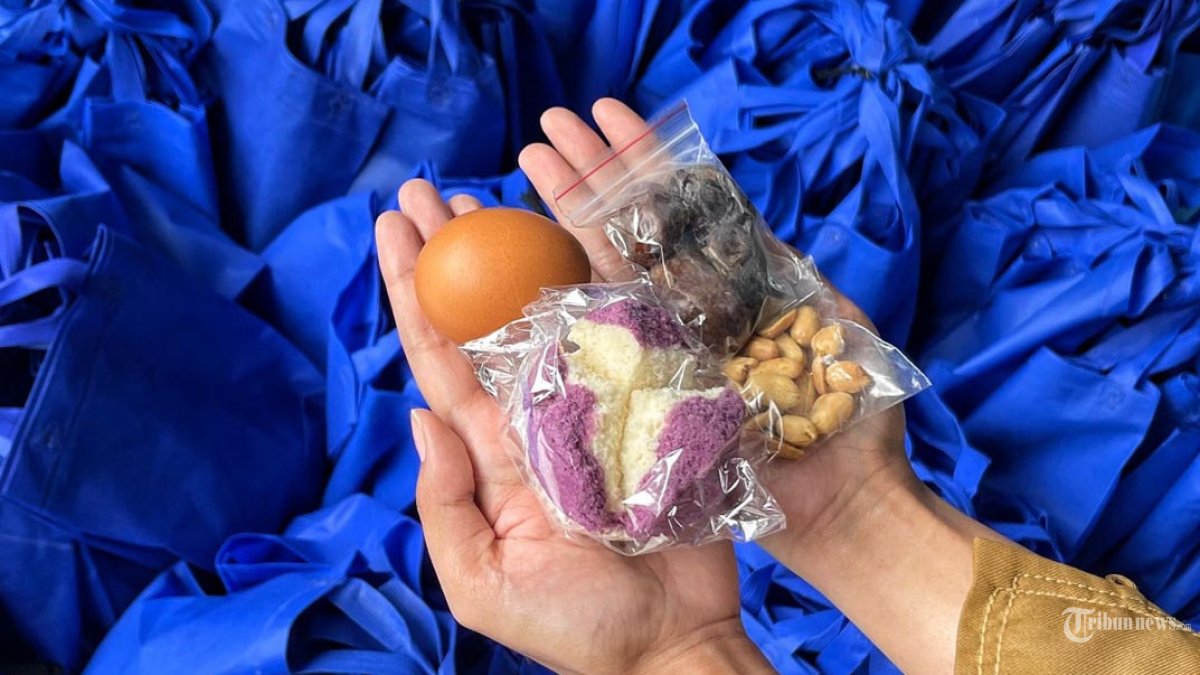 MBG RAMADAN - Guru memperlihatkan menu paket MBG (Makan Bergizi Gratis) ramadan di SMP N 6 Kota Malang, Jawa Timur, Senin (23/2/2026). Menu MBG ramadan tersebut yakni telur, kacang, roti, dan kurma. Pemerintah melalui Badan Gizi Nasional (BGN) akan terus mendistribusikan program Makan Bergizi Gratis (MBG) selama bulan Ramadan 2026 dengan penyesuaian mekanisme dan menu agar tetap mendukung nutrisi siswa yang berpuasa. SURYA/PURWANTO