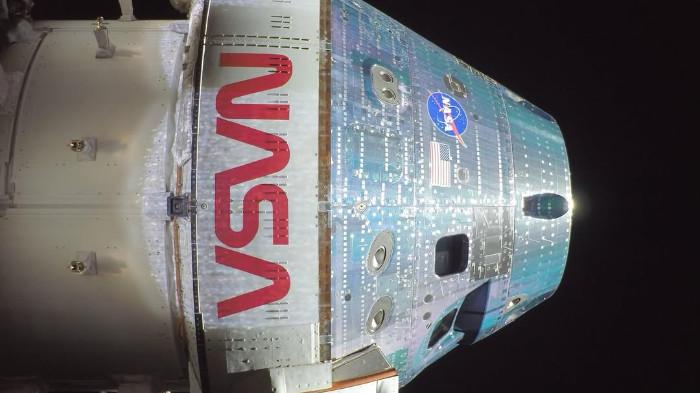 ORION ARTEMIS II - Wahana Orion terlihat sedang terbang dengan logo merah “worm” milik NASA yang tampak jelas pada bagian luarnya, dengan latar belakang ruang angkasa. Ini menjadi wahana yang membawa empat awak NASA yang menjalani misi Artemis II.