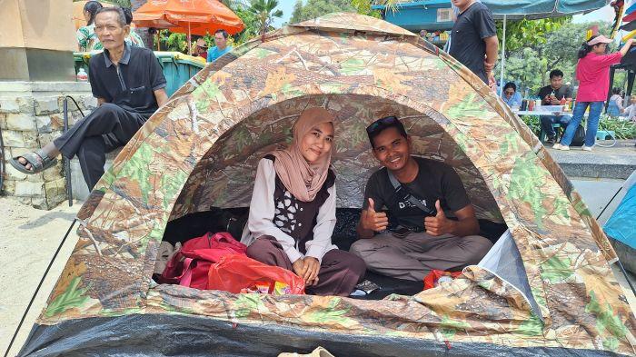 PIKNIK - Akmal dan Yuni di dalam tenda camping yang mereka bawa untuk menikmati libur lebaran di kawasan pantai Ancol, Jakarta Utara, Minggu (22/3/2026)