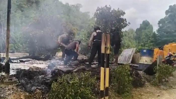 POS PENJAGAAN DIBAKAR - Petugas gabungan dari Polres Nabire dan Satgas Damai Cartenz melakukan penyisiran di lokasi kebakaran yang diduga dilakukan orang tak dikenal (OTK) di Kawasan perusahaan tambang PT Kristalin Ekalestari Nabire, Sabtu (21/2/2026).