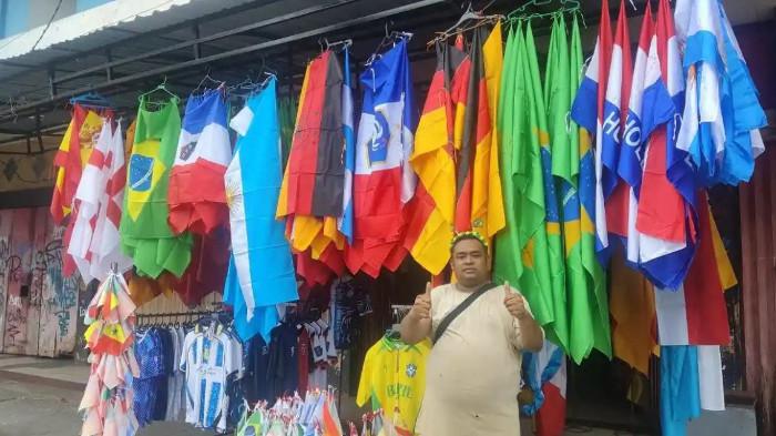 PIALA DUNIA 2026 - Pedagang bendera bersama sang istri saat melayani pembeli atribut Timnas Brasil dan negara peserta Piala Dunia 2026 di kawasan Abepura, Kota Jayapura, Kamis (28/5/2026). Atribut Brasil masih mendominasi pasaran di Abepura sebab mayoritas pembeli menyukai Brasil.