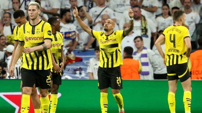 Pemain depan Borussia Dortmund asal Belanda bernomor punggung 21 Donyell Malen (tengah) merayakan golnya selama pertandingan sepak bola hari ketiga fase liga Liga Champions UEFA antara Real Madrid CF dan Borussia Dortmund di stadion Santiago Bernabeu di Madrid pada tanggal 22 Oktober 2024. (Foto oleh Pierre-Philippe MARCOU / AFP)