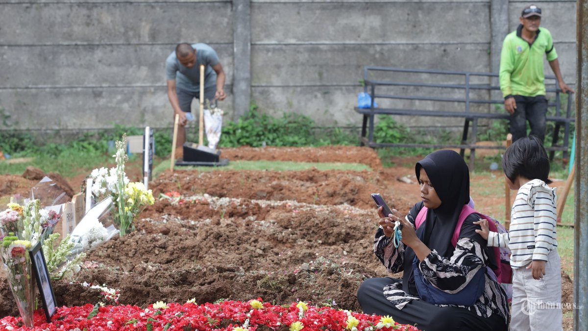 Keluarga berdoa di makam almarhumah Harum Anjasari di Tempat Pemakaman Umum (TPU) Cipayung, Jakarta Timur, Rabu (29/4/2026). Harum Anjasari menjadi salah satu korban meninggal dunia akibat kecelakaan Kereta Api Argo Bromo Anggrek dengan kereta rel listrik (KRL) di Stasiun Bekasi Timur. Tribunnews/Jeprima