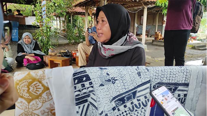 PERAJIN BATIK - Istijanah (56), berbagi kisah kepada wisatawan selama menjadi perajin batik tulis di Wukirsari, Imogiri, Bantul, Senin (20/10/2025).