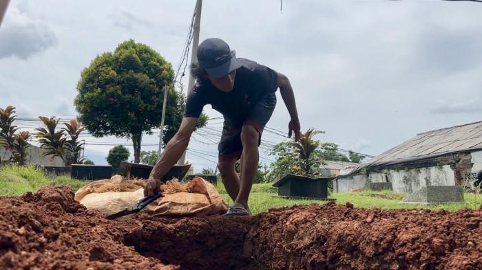 KEMATIAN ALVARO - Penggali kubur sedang menyiapkan liang kubur untuk jenazah Alvaro Kiano Nugroho, bocah 6 tahun yang ditemukan tewas setelah hilang delapan bulan, Rabu (26/11/2025). Lokasi pemakaman berada di tanah wakaf, Jalan Masjid Al Muflihun, Pesanggrahan, Jakarta Selatan. (Tribunnews/Alfarizy)