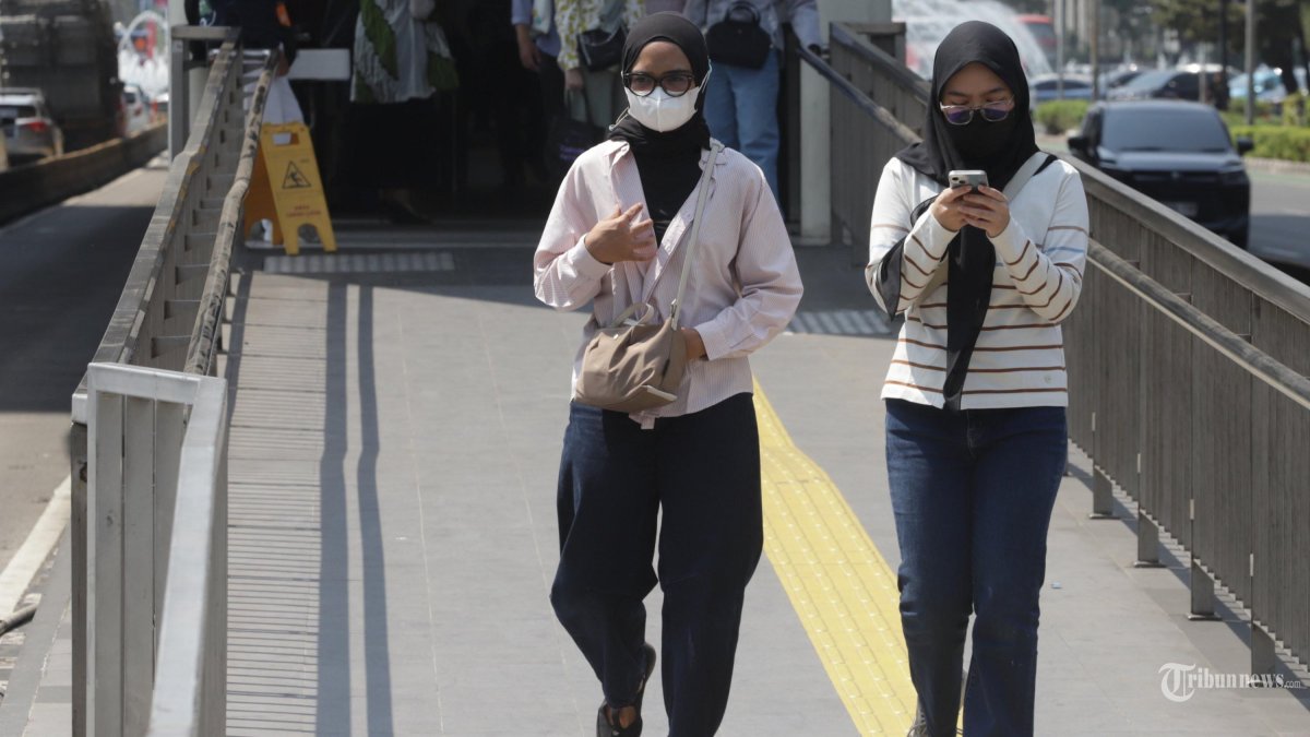 GANGGU KESEHATAN - Warga menggunakan masker saat berjalan kaki di kawasan Tosari, Jakarta, Minggu (6/9/2026). Pemerintah menghimbau kepada masyarakat untuk meningkatkan kewaspadaan dengan menggunakan masker saat beraktivitas di luar ruangan karena adanya indikasi sebaran abu vulkanik dari Gunung Anak Krakatau. TRIBUNNEWS/IRWAN RISMAWAN