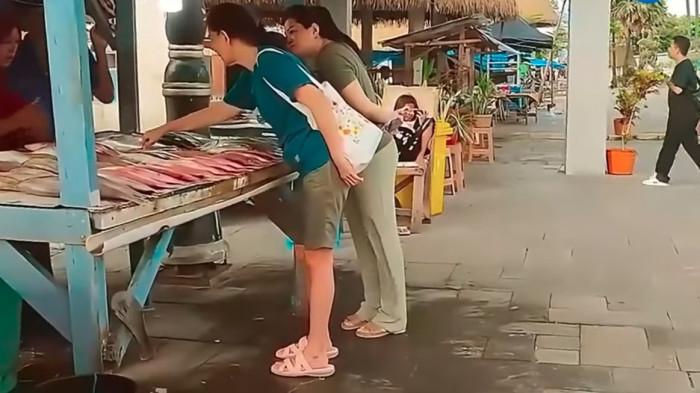 Pengunjung di Pantai Kelapa Lima yang tampak memilih jenis ikan segar untuk, kemudian dibakar di tempat. Liburan keluarga jadi lebih seru dan interaktif.