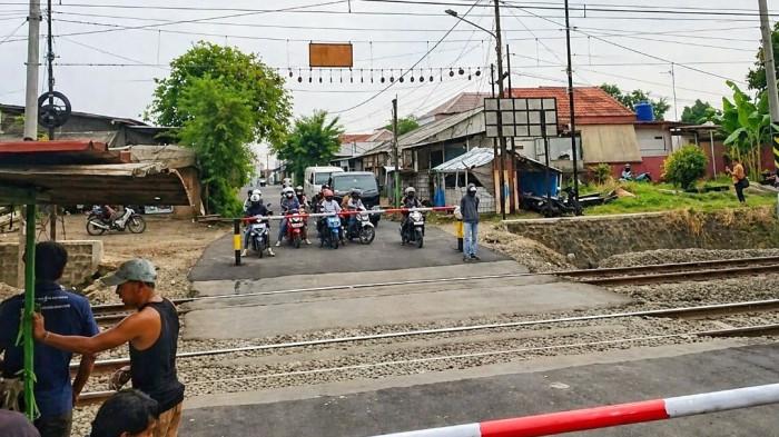 IRONI KESELAMATAN — Perlintasan liar kereta api di kawasan Bekasi Timur terpantau masih beroperasi menggunakan palang bambu manual pada Rabu (29/4/2026), meskipun baru saja menjadi lokasi tragedi maut yang merenggut belasan nyawa. Jalur berisiko tinggi tersebut tetap dijaga warga secara swadaya demi membantu mobilitas pengendara di tengah ketiadaan palang pintu otomatis resmi pasca-kecelakaan antara Kereta Rel Listrik (KRL) Commuter Line dan Kereta Api (KA) Argo Bromo Anggrek.