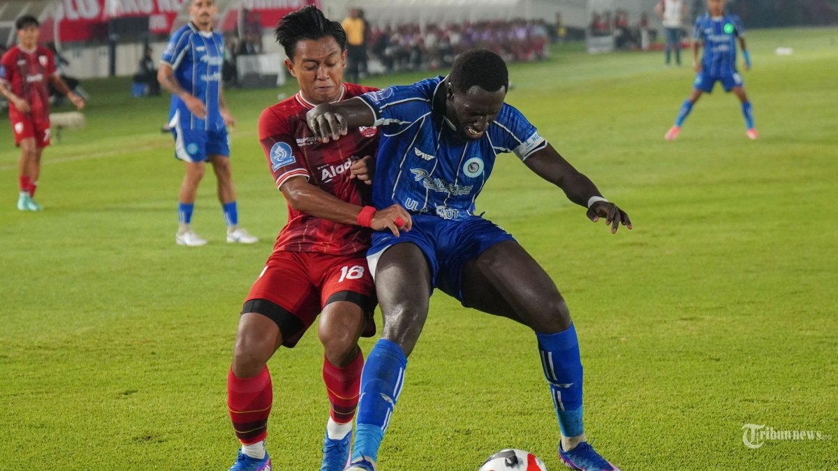 SUPER LEAGUE - Pesepak bola Persis Solo, Febri Hariyadi (kiri) berduel dengan pesepak bola PSBS Biak, Sandro Anibal dalam pertandingan Super League di Stadion Manahan, Solo, Sabtu (21/2/2026). PSBS Biak berhasil menahan imbang Persis Solo dengan skor 1-1. Tribun Solo/Muhammad Nursina