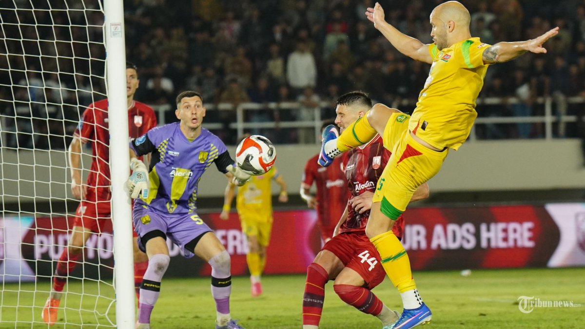 BEREBUT BOLA - Pesepak bola Persebaya, Risto Mitrevski (kanan) menyontek bola saat melawan Persis Solo dalam pertandingan Super League di Stadion Manahan, Solo, Sabtu (9/5/2026) malam. Laga Persis Solo vs Persebaya berakhir imbang tanpa gol. TRIBUNNEWS.COM/Muhammad Nursina