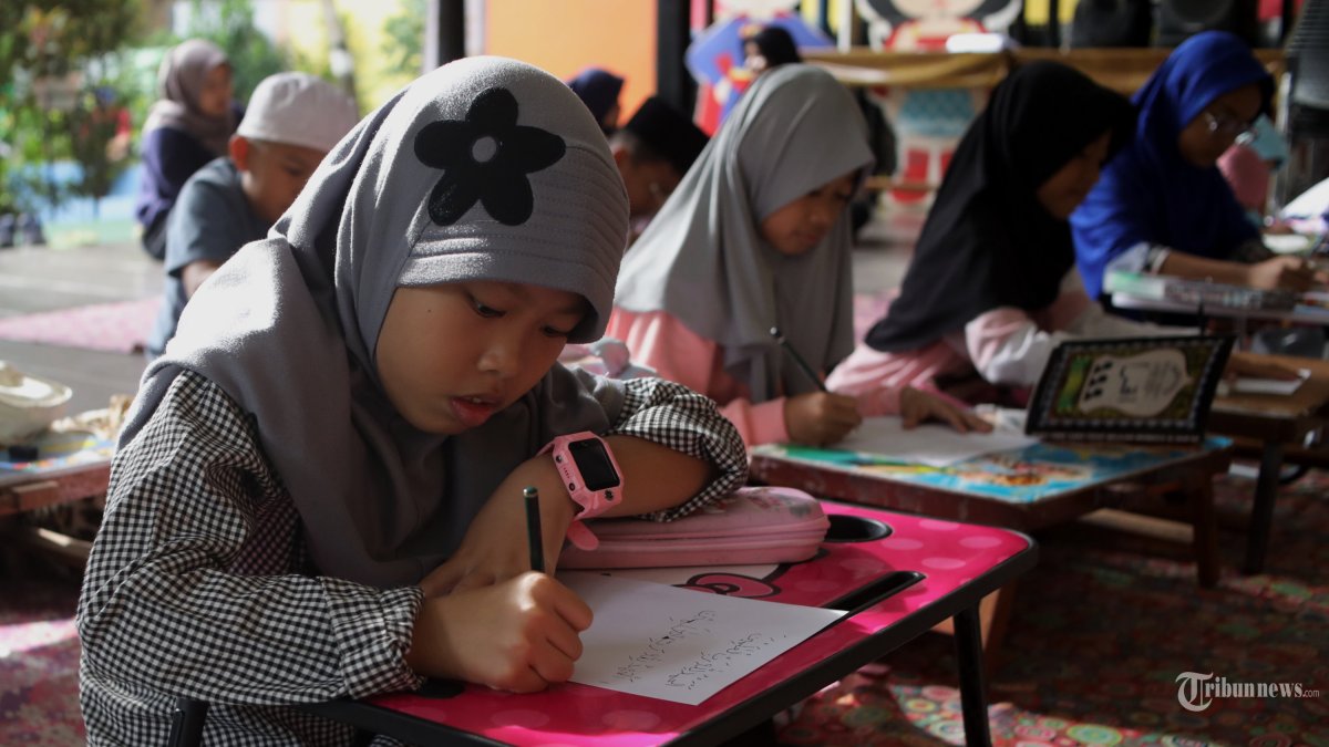 Sejumlah anak mengikuti kegiatan pesantren kilat Ramadan di RPTRA Malinjo, Jakarta, Minggu (1/3/2026). Kegiatan pesantren kilat yang dilaksanakan setiap bulan Ramadan tersebut diikuti puluhan peserta dari siswa jenjang TK-SD yang dibimbing oleh kelompok TP PKK Pejaten Barat untuk membekali ilmu agama anak usia dini, seperti belajar membaca Al-Quran dan Iqra, menghafal surat-surat pendek, menghafal doa-doa harian hingga edukasi tentang sejarah islam melalui dongeng dan film. TRIBUNNEWS/IRWAN RISMAWAN