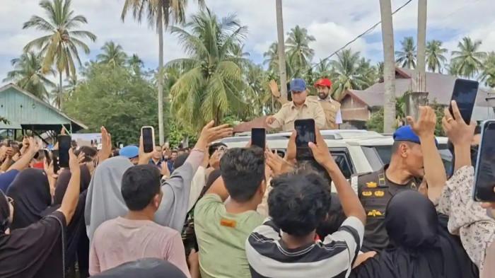 BANJIR SUMATERA – Presiden Prabowo Subianto, didampingi Gubernur Aceh Muzakir Manaf (Mualem) melambaikan tangan kepada warga dari atas mobil dinas kepresidenan Maung Garuda Limousine saat kunjungan ke Teupin Mane, Bireuen, Aceh, Minggu (7/12/2025). Prabowo menegaskan pemerintah akan segera merehabilitasi sawah petani yang rusak akibat banjir Sumatera.