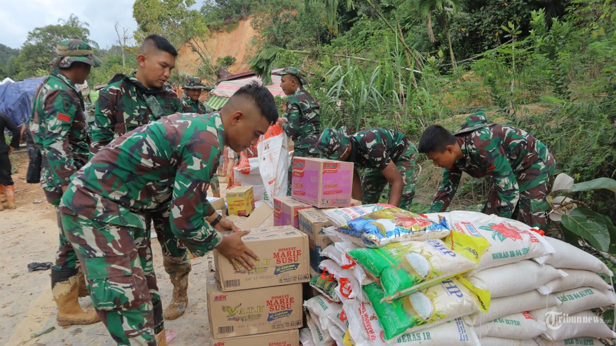 BERIKAN BANTUAN - Prajurit TNI dari Satuan Tugas (Satgas) Yonif 122/Tombak Sakti (TS) Kodam I/BB menyalurkan bantuan logistik untuk masyarakat terdampak bencana dengan menembus wilayah terisolir melewati medan berat di Kecamatan Sitahuis, Kabupaten Tapanuli Tengah, Sumatra Utara, Selasa (2/12/2025).  Untuk mencapai lokasi, prajurit harus memikul bantuan dan berjalan kaki puluhan kilometer dari titik terakhir yang masih dapat dilalui kendaraan. Adapun logistik yang dibawa meliputi 196 sak beras, 84 dus mi instan, 115 dus air mineral, 15 dus biskuit, serta tiga goni pakaian layak pakai. TRIBUNNEWS/HO/PUSPEN
