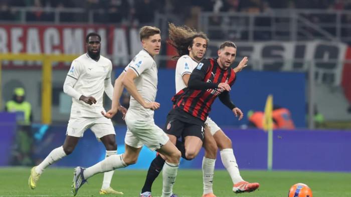 DUEL BOLA - Gelandang AC Milan Adrien Rabiot berebut bola dengan pemain Lazio dalam pertandingan pekan ke-13 Liga Italia, Minggu (30/11/2025). AC Milan menang tipis 1-0 dalam pertandingan yang digelar di San Siro itu.